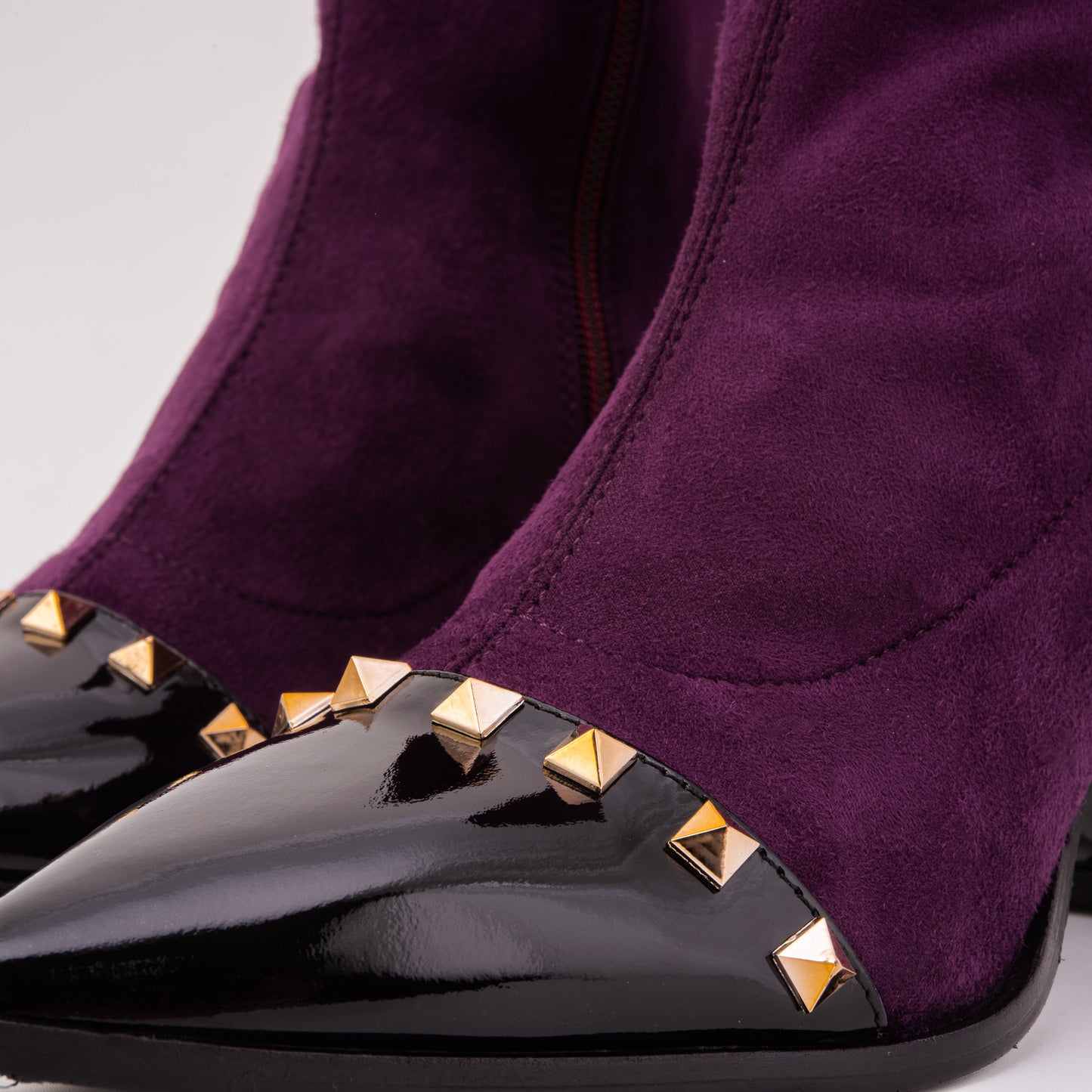 La bota de mujer de ante sintético púrpura intenso con tachuelas y amatista