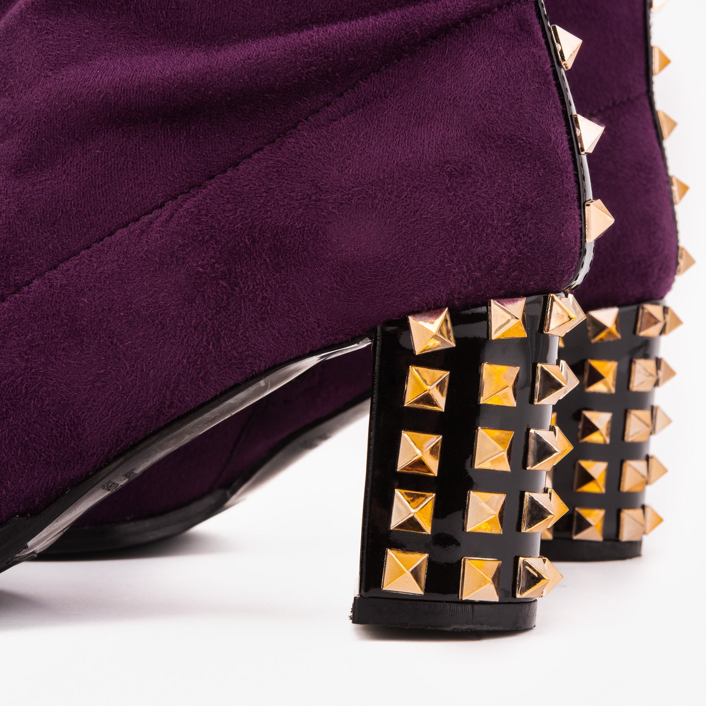 La bota de mujer de ante sintético púrpura intenso con tachuelas y amatista