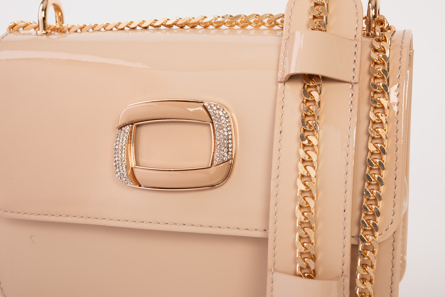 El bolso de mano de piel de charol color crema de Ferrara